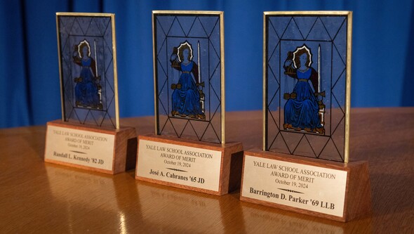 A closeup of the three Awards of Merit with a stained glass image and the recipients' names engraved on the base