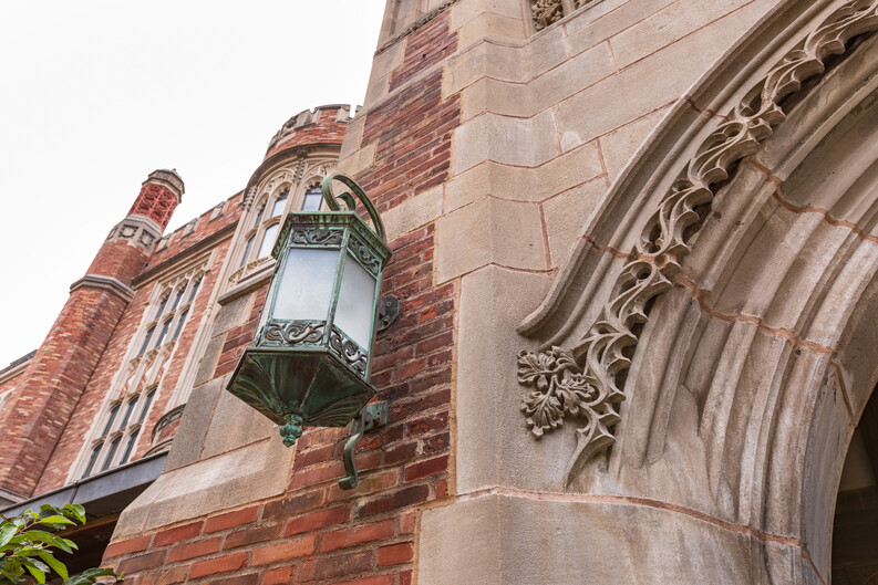 detail of a lantern at YLS against a brick and stone wall